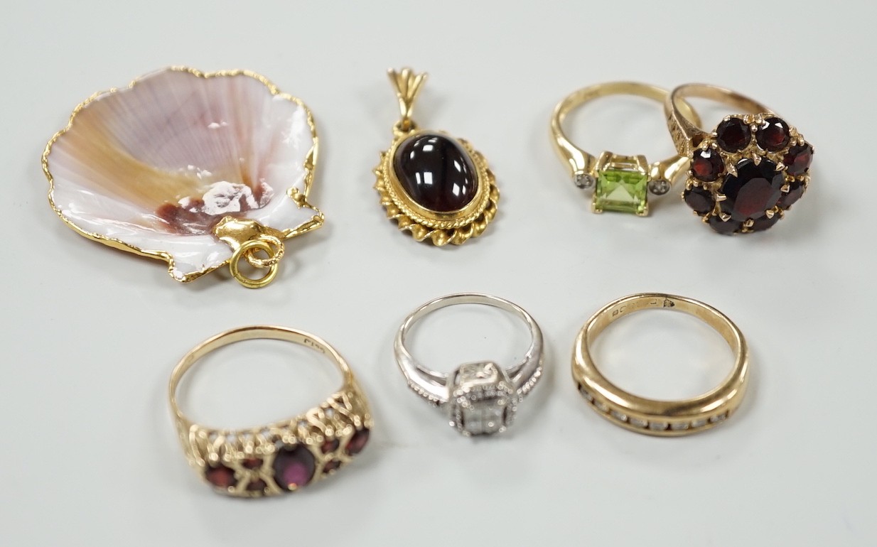 A 9ct and garner cluster set dress ring, size M, gross 4.9 grams, two yellow or white metal and diamond set rings, including half eternity and a yellow metal and garnet set half hoop ring, gross 8.8 grams, a 14k, single